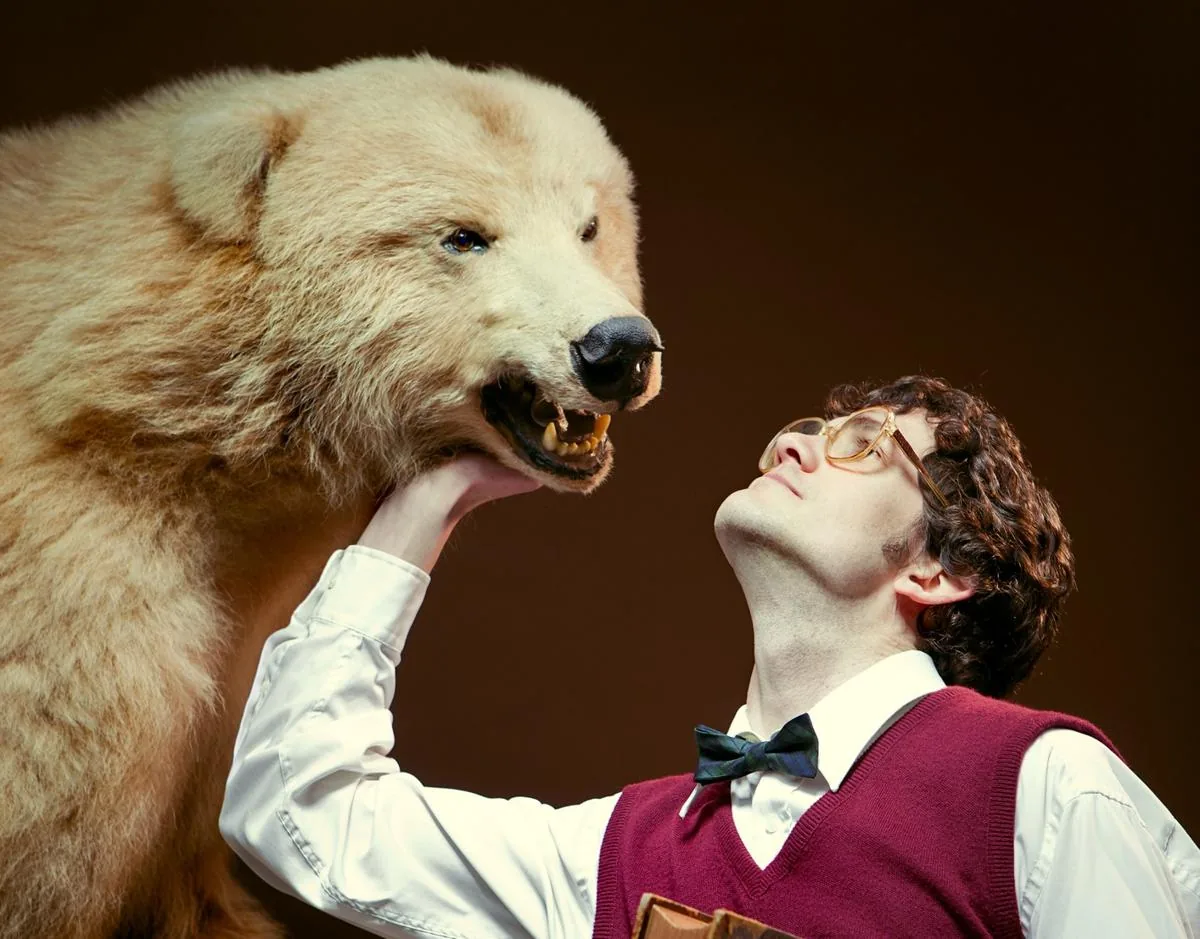 A grown man standing close to a large bear, showing how big a wild animal becomes as an adult