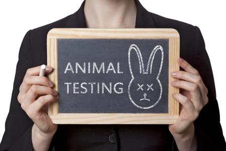 A person holding a sign against animal testing, representing public opposition to laboratory animal cruelty
